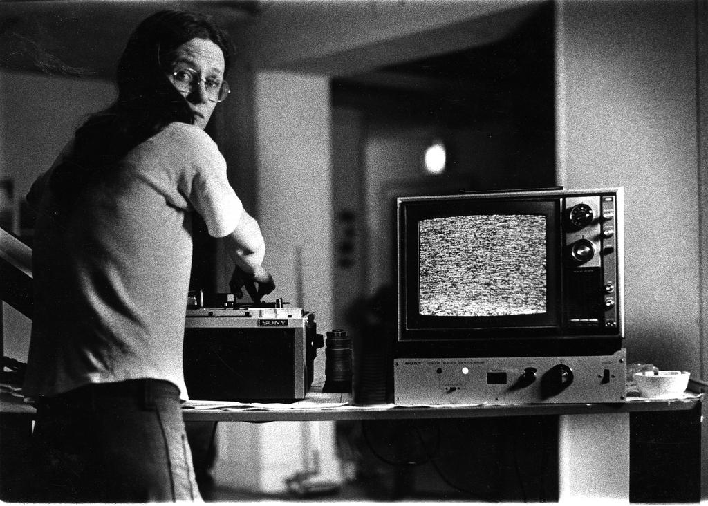 Sherry Miller Hocking at a tape deck beside a television monitor, 1972